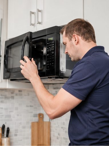 JT Service engineer repairing a microwave in London
